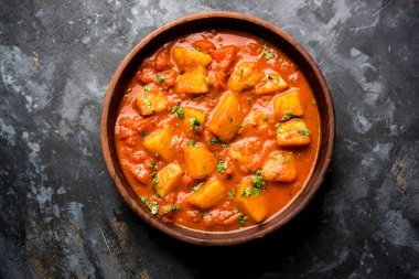 Hint yemeği - Aloo köri masala. Baharatlar ve otlar bir domates köri ile patates pişmiş. bir kapta moody arka plan üzerinde servis. seçici odak