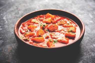 Hint yemeği - Aloo köri masala. Baharatlar ve otlar bir domates köri ile patates pişmiş. bir kapta moody arka plan üzerinde servis. seçici odak