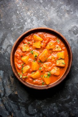 Hint yemeği - Aloo köri masala. Baharatlar ve otlar bir domates köri ile patates pişmiş. bir kapta moody arka plan üzerinde servis. seçici odak