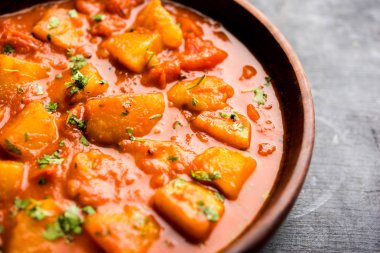Hint yemeği - Aloo köri masala. Baharatlar ve otlar bir domates köri ile patates pişmiş. bir kapta moody arka plan üzerinde servis. seçici odak