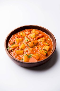 Hint yemeği - Aloo köri masala. Baharatlar ve otlar bir domates köri ile patates pişmiş. bir kapta moody arka plan üzerinde servis. seçici odak