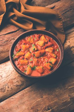 Hint yemeği - Aloo köri masala. Baharatlar ve otlar bir domates köri ile patates pişmiş. bir kapta moody arka plan üzerinde servis. seçici odak