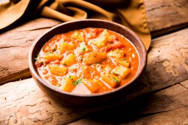 Hint yemeği - Aloo köri masala. Baharatlar ve otlar bir domates köri ile patates pişmiş. bir kapta moody arka plan üzerinde servis. seçici odak