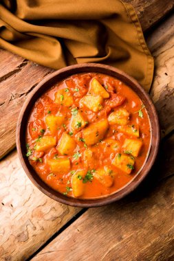 Hint yemeği - Aloo köri masala. Baharatlar ve otlar bir domates köri ile patates pişmiş. bir kapta moody arka plan üzerinde servis. seçici odak