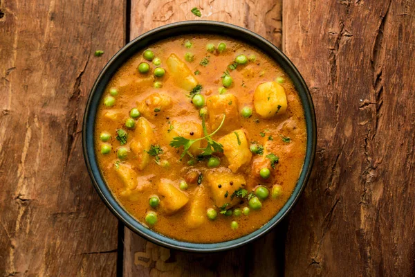 Hint Aloo Mutter köri - patates ve bezelye bir soğan domates et suyu dalmış ve kişniş yaprakları ile süslenmiş. Bir Karahi/kadhai veya pan veya kase servis. seçici odak