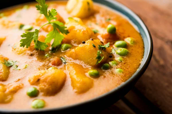 Hint Aloo Mutter köri - patates ve bezelye bir soğan domates et suyu dalmış ve kişniş yaprakları ile süslenmiş. Bir Karahi/kadhai veya pan veya kase servis. seçici odak