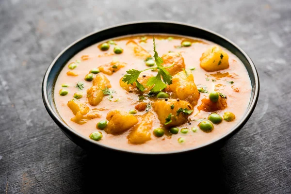 Hint Aloo Mutter köri - patates ve bezelye bir soğan domates et suyu dalmış ve kişniş yaprakları ile süslenmiş. Bir Karahi/kadhai veya pan veya kase servis. seçici odak