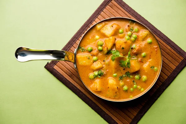 Hint Aloo Mutter köri - patates ve bezelye bir soğan domates et suyu dalmış ve kişniş yaprakları ile süslenmiş. Bir Karahi/kadhai veya pan veya kase servis. seçici odak