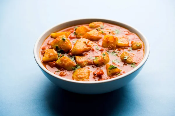 Hint yemeği - Aloo köri masala. Baharatlar ve otlar bir domates köri ile patates pişmiş. bir kapta moody arka plan üzerinde servis. seçici odak