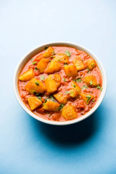 Hint yemeği - Aloo köri masala. Baharatlar ve otlar bir domates köri ile patates pişmiş. bir kapta moody arka plan üzerinde servis. seçici odak