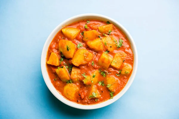 Hint yemeği - Aloo köri masala. Baharatlar ve otlar bir domates köri ile patates pişmiş. bir kapta moody arka plan üzerinde servis. seçici odak