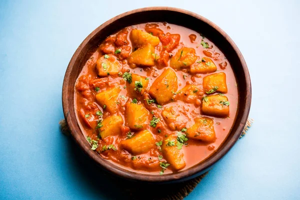 Hint yemeği - Aloo köri masala. Baharatlar ve otlar bir domates köri ile patates pişmiş. bir kapta moody arka plan üzerinde servis. seçici odak