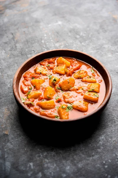 Hint yemeği - Aloo köri masala. Baharatlar ve otlar bir domates köri ile patates pişmiş. bir kapta moody arka plan üzerinde servis. seçici odak