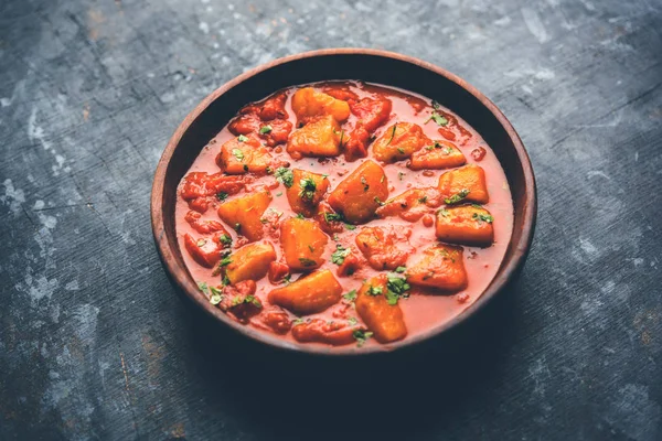 Hint yemeği - Aloo köri masala. Baharatlar ve otlar bir domates köri ile patates pişmiş. bir kapta moody arka plan üzerinde servis. seçici odak