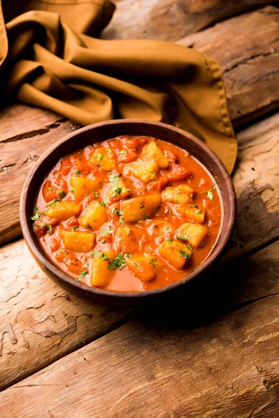 Hint yemeği - Aloo köri masala. Baharatlar ve otlar bir domates köri ile patates pişmiş. bir kapta moody arka plan üzerinde servis. seçici odak