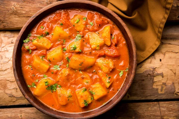 Hint yemeği - Aloo köri masala. Baharatlar ve otlar bir domates köri ile patates pişmiş. bir kapta moody arka plan üzerinde servis. seçici odak