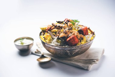 Hint tavuk Tikka Biriyani bir kase yoğurt ile servis. seçici odak