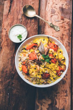 Hint tavuk Tikka Biriyani bir kase yoğurt ile servis. seçici odak