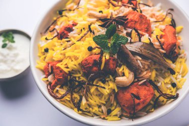 Hint tavuk Tikka Biriyani bir kase yoğurt ile servis. seçici odak