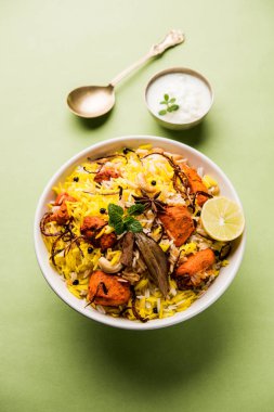 Hint tavuk Tikka Biriyani bir kase yoğurt ile servis. seçici odak