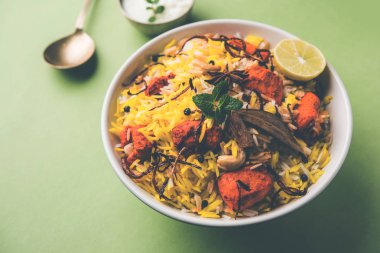 Hint tavuk Tikka Biriyani bir kase yoğurt ile servis. seçici odak