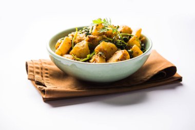Aloo Palak Sabzi, baharatlı ıspanakla pişirilmiş patates. Sağlıklı bir Hint yemeği tarifi. Bir kasede servis edilmiş, seçici bir odak noktası.