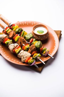 Hariyali kakab tavuk mu Malai malai Kebap tricolour içinde servis ile şiş ve yoğurt dip bir tabak içinde. seçici odak