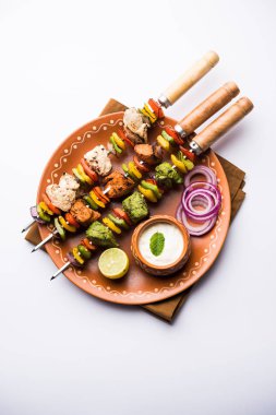 Hariyali kakab tavuk mu Malai malai Kebap tricolour içinde servis ile şiş ve yoğurt dip bir tabak içinde. seçici odak