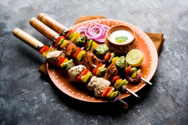 Hariyali kakab tavuk mu Malai malai Kebap tricolour içinde servis ile şiş ve yoğurt dip bir tabak içinde. seçici odak