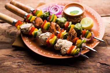 Hariyali kakab tavuk mu Malai malai Kebap tricolour içinde servis ile şiş ve yoğurt dip bir tabak içinde. seçici odak