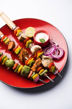 Hariyali kakab tavuk mu ile hizmet Malai Kebap şişleri ve yoğurt dip bir tabak içinde. seçici odak