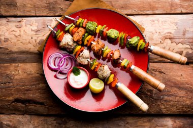 Hariyali kakab tavuk mu ile hizmet Malai Kebap şişleri ve yoğurt dip bir tabak içinde. seçici odak