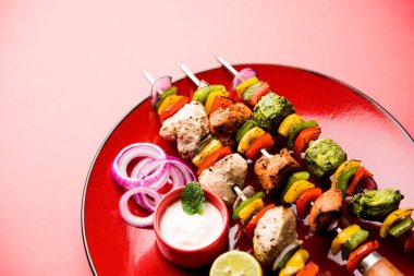 Hariyali kakab tavuk mu ile hizmet Malai Kebap şişleri ve yoğurt dip bir tabak içinde. seçici odak