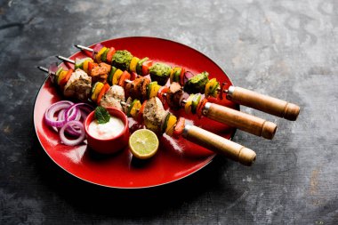 Hariyali kakab tavuk mu ile hizmet Malai Kebap şişleri ve yoğurt dip bir tabak içinde. seçici odak