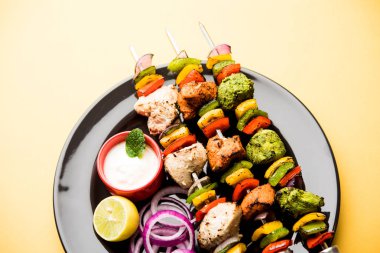 Hariyali kakab tavuk mu ile hizmet Malai Kebap şişleri ve yoğurt dip bir tabak içinde. seçici odak