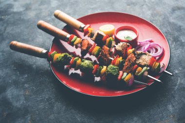 Hariyali kakab tavuk mu ile hizmet Malai Kebap şişleri ve yoğurt dip bir tabak içinde. seçici odak