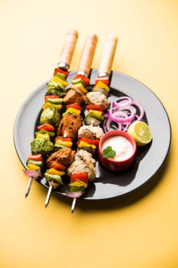 Hariyali kakab tavuk mu ile hizmet Malai Kebap şişleri ve yoğurt dip bir tabak içinde. seçici odak