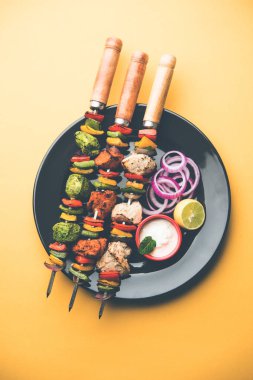 Hariyali kakab tavuk mu ile hizmet Malai Kebap şişleri ve yoğurt dip bir tabak içinde. seçici odak