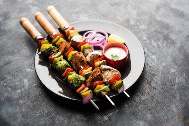 Hariyali kakab tavuk mu ile hizmet Malai Kebap şişleri ve yoğurt dip bir tabak içinde. seçici odak