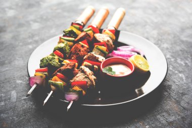 Hariyali kakab tavuk mu ile hizmet Malai Kebap şişleri ve yoğurt dip bir tabak içinde. seçici odak