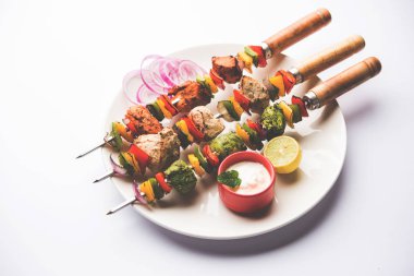 Hariyali kakab tavuk mu ile hizmet Malai Kebap şişleri ve yoğurt dip bir tabak içinde. seçici odak