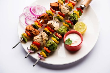 Hariyali kakab tavuk mu ile hizmet Malai Kebap şişleri ve yoğurt dip bir tabak içinde. seçici odak