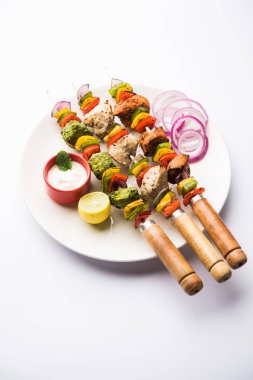 Hariyali kakab tavuk mu ile hizmet Malai Kebap şişleri ve yoğurt dip bir tabak içinde. seçici odak