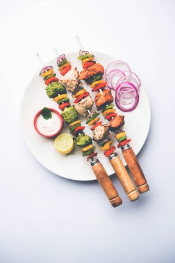 Hariyali kakab tavuk mu ile hizmet Malai Kebap şişleri ve yoğurt dip bir tabak içinde. seçici odak