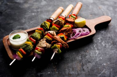 Hariyali kakab tavuk mu ile hizmet Malai Kebap şişleri ve yoğurt dip bir tabak içinde. seçici odak