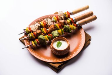 Hariyali kakab tavuk mu ile hizmet Malai Kebap şişleri ve yoğurt dip bir tabak içinde. seçici odak