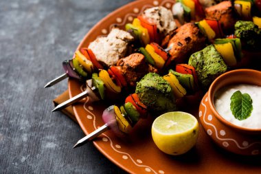 Hariyali kakab tavuk mu ile hizmet Malai Kebap şişleri ve yoğurt dip bir tabak içinde. seçici odak