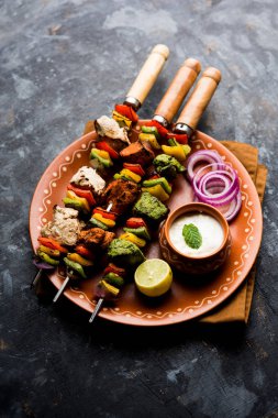 Hariyali kakab tavuk mu ile hizmet Malai malai Kebap şişleri ve yoğurt dip bir tabak içinde. seçici odak