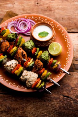 Hariyali kakab tavuk mu ile hizmet Malai malai Kebap şişleri ve yoğurt dip bir tabak içinde. seçici odak