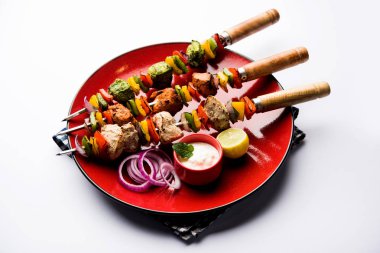 Hariyali kakab tavuk mu ile hizmet Malai malai Kebap şişleri ve yoğurt dip bir tabak içinde. seçici odak